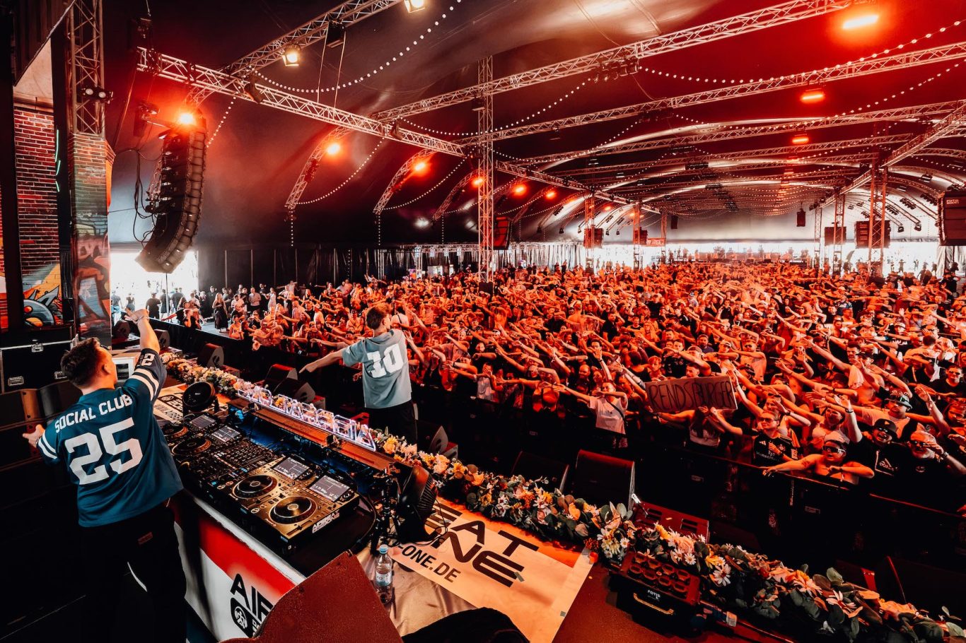 AIRBEAT ONE sprengt Besucherrekord - 210.000 feiern die „Netherlands Edition“ Ein überfülltes Veranstaltungszelt mit jubelndem Publikum und einem DJ an der Bühne.